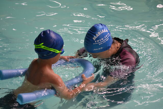 Instructor helping a learner with a pool noodle