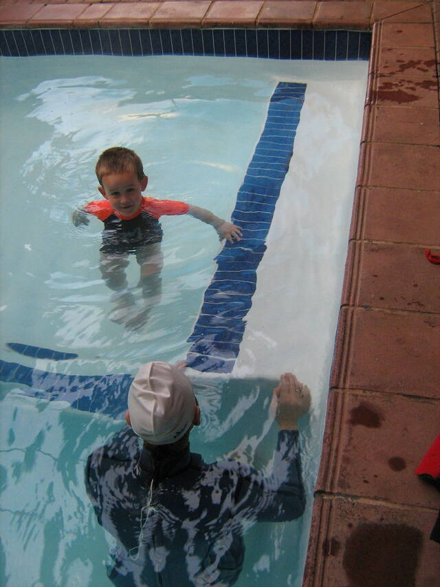 Child swimming to the pool wall