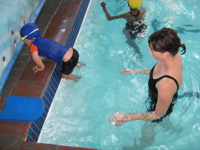 Instructor and child at the pool edge